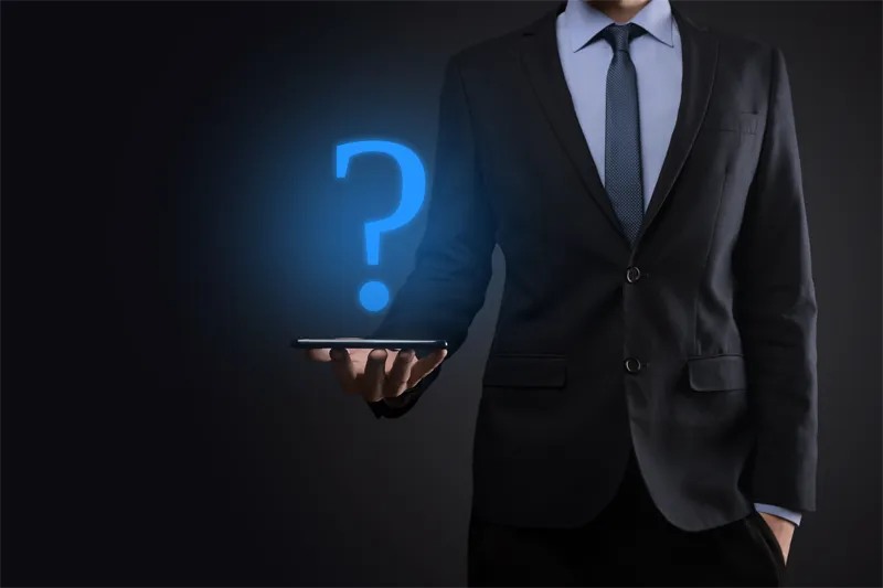 Man in suit holding a tablet with a glowing question mark.